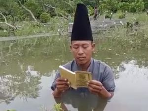 MUI Gresik Sentil Pria Baca Yasin di Tengah Makam yang Banjir demi Konten
