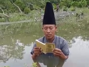 MUI Gresik Sentil Pria Baca Yasin di Tengah Makam yang Banjir demi Konten