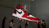 Orang-orang mengambil foto patung Air Jordan 1 Chicago Air dari karton daur ulang karya seniman Michael Murph.