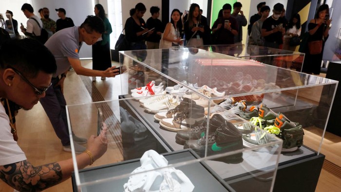 Visitors take photos of limited edition sneakers from Singapore singer JJ Lin's private collection during the media preview of Sneakertopia, a sneaker and street culture exhibition, at the Art Science Museum in Singapore February 23, 2023. REUTERS/Edgar Su