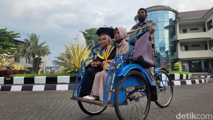 Ema Muktiani (23) diantar orangtuanya menggunakan becak saat akan menghadiri prosesi wisuda di Universitas Muhammadiyah Purwokerto, Sabtu (25/2/2023).