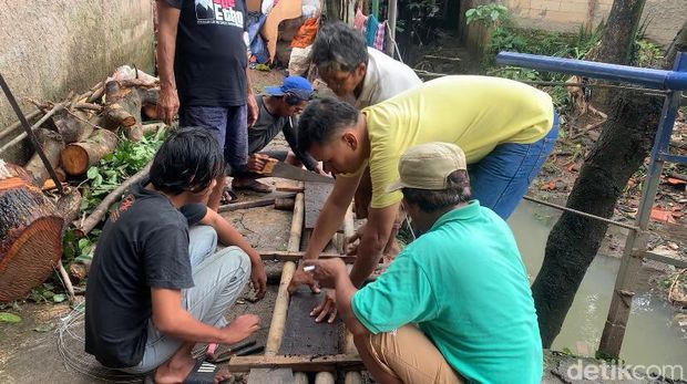 Gotong royong warga Cipinang Melayu memperbaiki sementara jembatan rusak akibat tertimpa pohon (Mulia/detikcom)