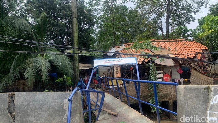 Gotong royong warga Cipinang Melayu memperbaiki sementara jembatan rusak akibat tertimpa pohon (Mulia/detikcom)