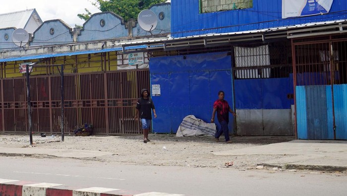 Dua warga melintasi pertokoan yang tutup pascabentokan warga di jalan Yos Sudarso Wamena, Provinsi Papua Pegunungan, Sabtu (25/2/2023). Warga Wamena masih takut keluar rumah pascakerusuhan yang dipicu isu penculikan anak  yang mengakibatkan 12 warga meninggal dunia. ANTARA FOTO/Iwan Adisaputra/wpa/hp.