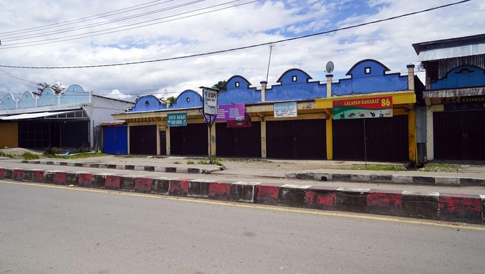 Dua warga melintasi pertokoan yang tutup pascabentokan warga di jalan Yos Sudarso Wamena, Provinsi Papua Pegunungan, Sabtu (25/2/2023). Warga Wamena masih takut keluar rumah pascakerusuhan yang dipicu isu penculikan anak  yang mengakibatkan 12 warga meninggal dunia. ANTARA FOTO/Iwan Adisaputra/wpa/hp.