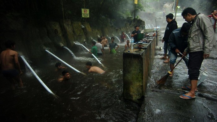 PEMANDIAN AIR PANAS TUTUP PASCA BANJIR BANDANG Petugas dibantu warga membersihkan tempat pemandian air panas pancuran 13 di Obyek Wisata Guci, Kabupaten Tegal, Jawa Tengah, Sabtu (25/2/2023). Tempat pemandian air panas pancuran 13 penuh ditutup sementara akibat penuh pasir dan sejumlah pipa rusak sehingga suplai air bersih di tempat penginapan terhambat pasca banjir bandang Jumat (24/2/2023) malam. ANTARA FOTO/Oky Lukmansyah