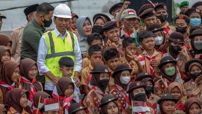 Presiden Joko Widodo (tengah) bersama cucunya Jan Ethes berfoto bersama sejumlah pelajar seusai meresmikan Jalan Tol Semarang-Demak Seksi II di Gerbang Tol Sayung, Kabupaten Demak, Jawa Tengah, Sabtu (25/2/2023). Presiden Joko Widodo berharap jalan tol sepanjang 16,01 Km Seksi II ruas Sayung-Demak yang menelan anggaran sekitar Rp5,9 triliun itu bisa mengintegrasikan efisiensi transportasi logistik kawasan pertanian, perkebunan, industri dan pariwisata yang melewati Jalur Pantura. ANTARA FOTO/Aji Styawan/aww.