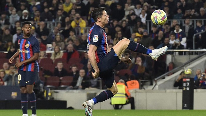Barcelonas Spanish forward Ansu Fati (L) looks at Barcelonas Polish forward Robert Lewandowski kicking the ball during the Spanish League football match between FC Barcelona and Cadiz CF at the Camp Nou stadium in Barcelona, on February 19, 2023. (Photo by Pau BARRENA / AFP)