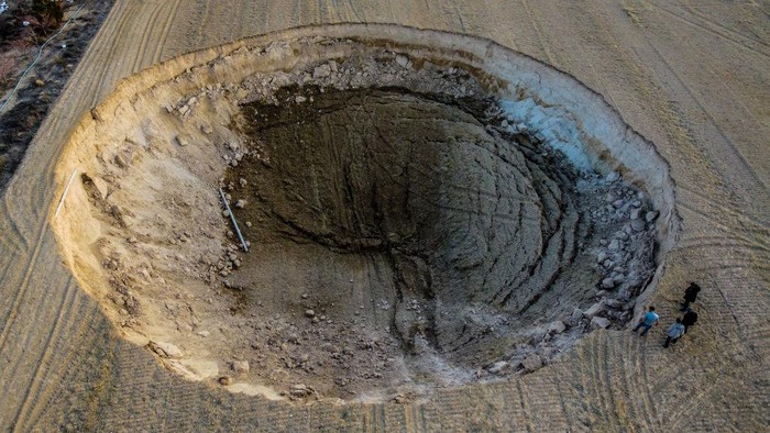KONYA, TURKIYE - FEBRUARY 24: An aerial view of a sinkhole in a crop field in Karapinar district of Konya province, Turkiye on February 24, 2022. Sinkhole measured approximately 37-metres in diameter and 12-metres in depth. (Photo by Fatih Arslan/Anadolu Agency via Getty Images)