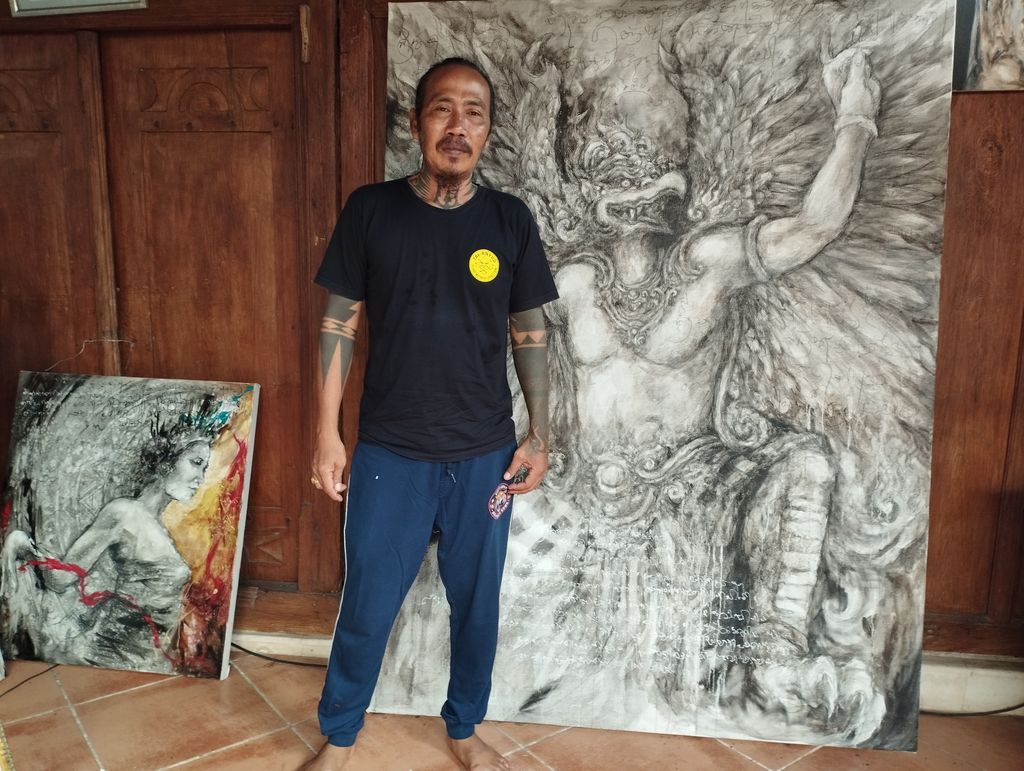 I Wayan Hendrawan melukis menggunakan abu vulkanik yang digunakan sebagai campuran pewarna. (Nuranda Indrajaya)