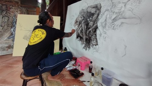 I Wayan Hendrawan melukis menggunakan abu vulkanik yang digunakan sebagai campuran pewarna. (Nuranda Indrajaya)