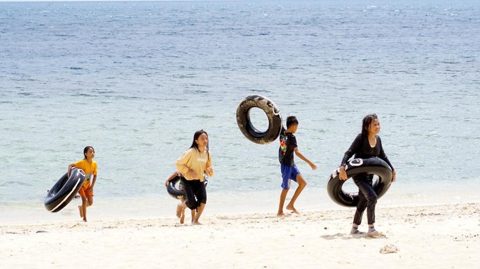 Sejumlah wisatawan bermain di objek wisata Pantai Kurenai di Kabupaten Bone Bolango, Gorontalo, Minggu (26/2/2023). Salah satu objek wisata bahari unggulan Bone Bolango tersebut menambah sejumlah fasilitas penunjang bagi wisatawan seperti perahu wisata dan tempat kuliner. ANTARA FOTO/Adiwinata Solihin/nz