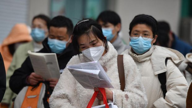 Peserta ujian China meninjau materi studi saat mereka menunggu untuk menghadiri ujian perekrutan pegawai negeri tahunan China untuk bersaing mendapatkan lowongan dengan otoritas pusat dan cabang mereka pada 25 Februari 2023 di Fuyang, Provinsi Anhui China. (VCG/VCG via Getty Images)
