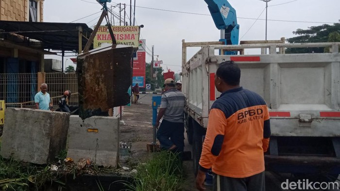Petugas mengevakuasi balok beton yang menyumbat selokan di Ceper, Klaten, Minggu (26/1/2023).