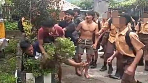 Tangkapan layar perkelahian dua orang pemuda di halaman salah satu SMPN di Kecamatan Banjar, Kabupaten Buleleng, Bali viral di media sosial. (IST)