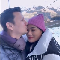 Berpose di Swiss yang sedang bersalju, keduanya tampak begitu lengket seolah tak terpisahkan. Christian Sugiono juga tampak mencium kening sang istri dengan mesra. Foto: Instagram/@titi_kamall