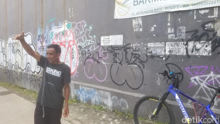 Wawan (40) tengah mengatur lalu lintas di gang perbatasan Kabupaten dan Kota Bandung