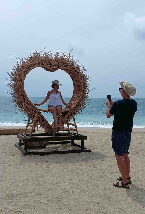 Wisatawan asing asal Australia, Paul dan Christina dari Jakarta nampak berfoto di spot berbentuk love yang ada di Pantai Jerman, Minggu (26/2/2023). (Triwidiyanti/detikBali)