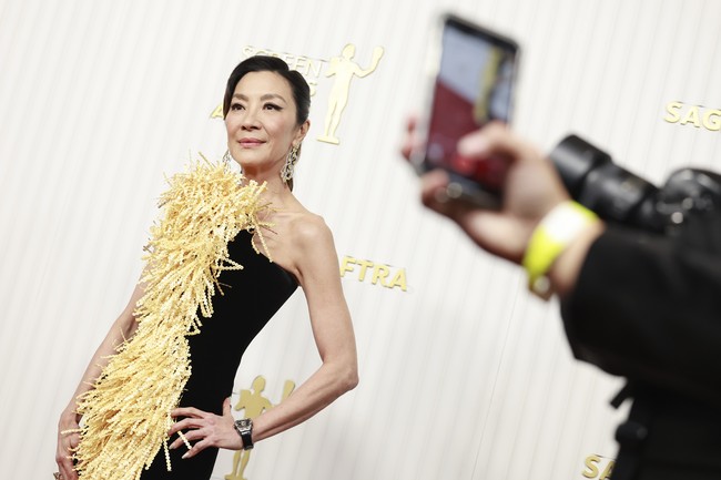 Michelle Yeoh menikmati atensi yang tertuju padanya dalam balutan column-dress Schiaparelli.yang dihiasi panel berbulu. (Foto: Emma McIntyre/FilmMagic)