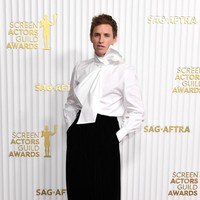 Tak hanya wanita, para pria pun tampil total. Aktor Eddie Redmaynes menebar pesonanya dengan blus yang dihiasi pita jumbo. (Foto: VALERIE MACON/AFP via Getty Images)