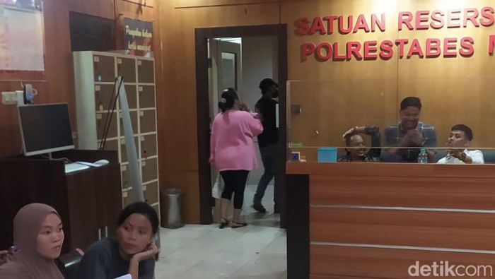 Dea Puspita Sari (pink) mendatangi Polrestabes Makassar terkait kasus dugaan dirinya dianiaya penjual baju bekas.