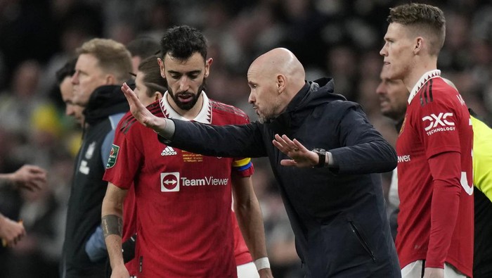 Manchester Uniteds head coach Erik ten Hag, centre, talks to Bruno Fernandes, left, during the English League Cup final soccer match between Manchester United and Newcastle United at Wembley Stadium in London, Sunday, Feb. 26, 2023. (AP Photo/Alastair Grant)