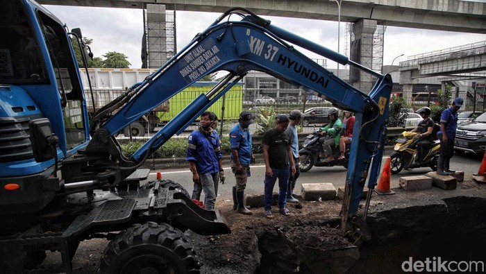 Jalan RA Kartini, Cilandak, Jakarta Selatan, yang amblas dan menyebabkan kemacetan kini tengah diperbaiki. Dua alat berat dikerahkan dalam proses perbaikan ini.