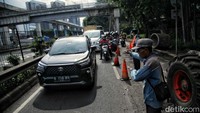 Petugas mengatur lalu lintas di lokasi jalan yang amblas.