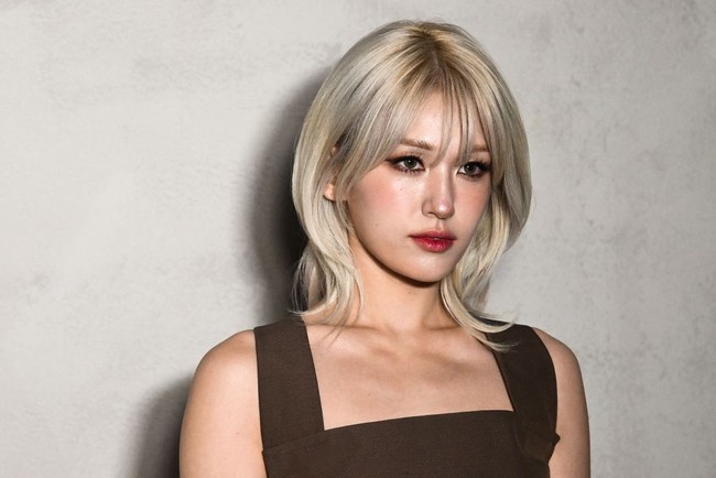 Aura seksi juga ditampilkan Jeon Somi lewat riasan wajah. Matanya dirias dengan gaya smokey eyes dan eyeliner hitam pekat. Foto: AFP via Getty Images/MARCO BERTORELLO