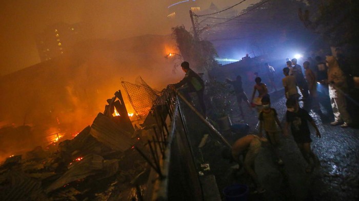Sejumlah warga menyaksikan kebakaran permukiman di kawasan Tanah Abang, Jakarta, Minggu (26/2/2023).Penyebab kebakaran permukiman tersebut masih dalam penyelidikan pihak berwajib. ANTARA FOTO/Fauzan/nz