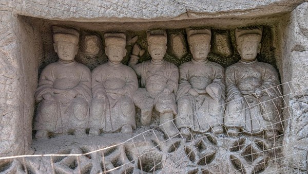 Patung-patung Buddha itu tampak diukir di sebuah batu besar.  