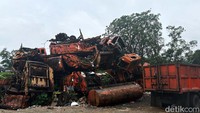 Beberapa truk sampah terlihat masih berbentuk. Truk itu terparkir di depan tumpukan truk.