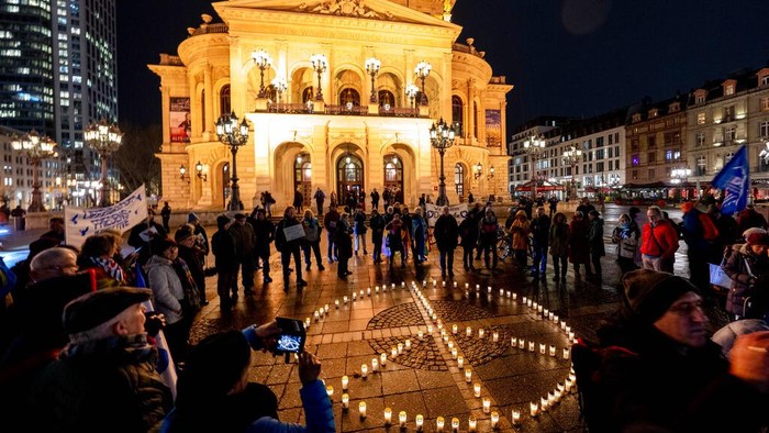 Ragam Aksi Dunia Sikapi Satu Tahun Invasi Rusia ke Ukraina People light candles forming a peace sign in front of the Old Opera to mark the first anniversary of Russia's full-scale invasion of Ukraine in Frankfurt, Germany, Friday, Feb. 24, 2023. (AP Photo/Michael Probst)