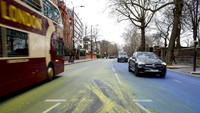 Cat biru dan kuning yang mewakili warna bendera Ukraina menutupi jalan di luar Kedutaan Besar Rusia di London. AP/David Cliff