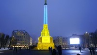 Monumen Kebebasan diterangi dengan warna bendera nasional Ukraina untuk menandai peringatan satu tahun invasi Rusia ke negara itu, di Riga, Latvia. AP/Roman Koksarov  