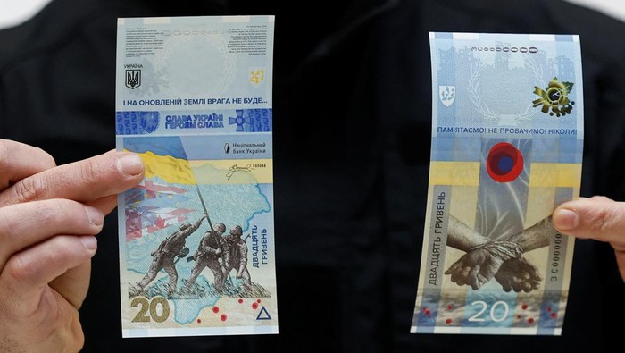 Governor of the National Bank of Ukraine Andriy Pyshnyi holds banknotes dedicated to the first anniversary of Russia's invasion on Ukraine, during a presentation in Kyiv, Ukraine February 23, 2023. REUTERS/Valentyn Ogirenko