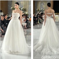 Gaun pengantin putih polos yang satu ini juga tak kalah menawan. Masih merupakan rancangan desainer Vera Wang, gaun pengantin tanpa lengan ini memiliki aksen sedikit transparan pada bagian perutnya. Bagian belakang gaun pun tak kalah cantik nan seksi dengan potongan punggung yang cukup rendah. Foto: Wolipop/Vina Oktiani