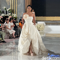 Masih dari rancangan desainer Oscar de la Renta, gaun pengantin tanpa lengan berwarna broken white yang satu ini juga tak kalah memukau. Cocok bagi kamu yang menginginkan gaun pengantin semi ball gown namun tetap terlihat simpel. Pada salah satu bagian dadanya terdapat aksen berbentuk bungan yang cukup besar dan berwarna senada dengan gaun tersebut. Foto: Wolipop/Vina Oktiani