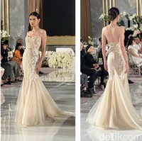 Tak selalu berwarna putih, gaun pengantin berwarna coklat keemasan yang satu ini juga bisa dijadikan pilihan. Gaun yang berasal dari Berta itu berbentuk mermaid dengan bagian atas tak berlengan. Bagian belakang gaun memiliki sedikit buntut namun tetap terlihat simpel. Foto: Wolipop/Vina Oktiani