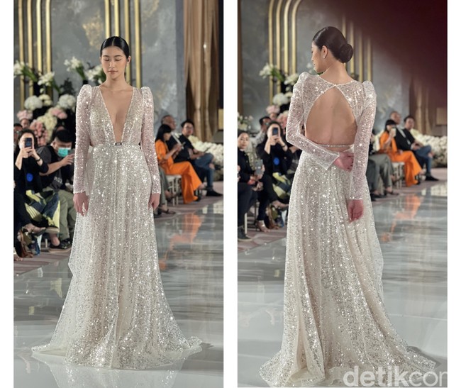 Gaun pengantin cantik yang satu ini sangat cocok untuk acara malam hari. Dengan bahan yang bling-bling akan membuat penampilan jadi terlihat mewah dan glamor. Gaun berwarna silver rancangan Berta ini cocok bagi kamu yang ingin tampil lebih tertutup namun tetap seksi dengan potongan dada berbentuk v yang cukup rendah dan bagian punggung yang terbuka. Foto: Wolipop/Vina Oktiani