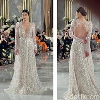Gaun pengantin cantik yang satu ini sangat cocok untuk acara malam hari. Dengan bahan yang bling-bling akan membuat penampilan jadi terlihat mewah dan glamor. Gaun berwarna silver rancangan Berta ini cocok bagi kamu yang ingin tampil lebih tertutup namun tetap seksi dengan potongan dada berbentuk v yang cukup rendah dan bagian punggung yang terbuka. Foto: Wolipop/Vina Oktiani