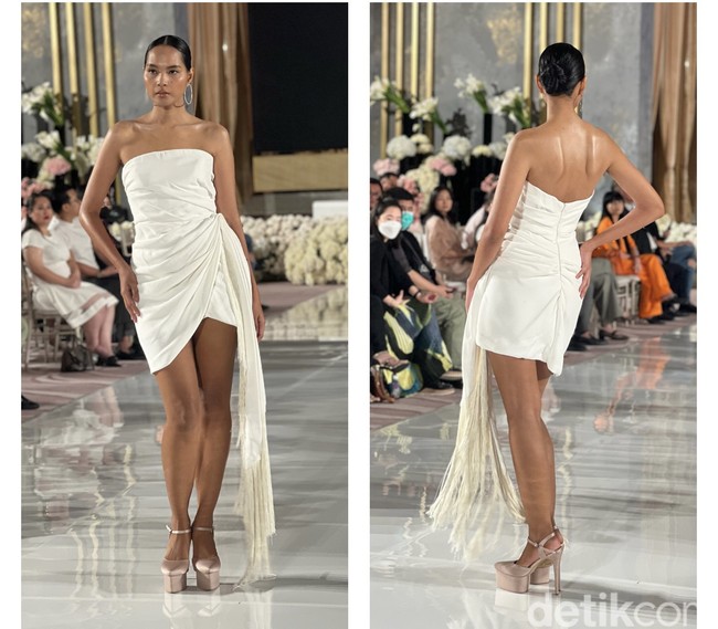 Jika kamu mengadakan pesta pernikahan outdoor, maka gaun pengantin putih pendek yang satu ini sangat cocok dan bisa dijadikan inspirasi. Gaun karya desainer Oscar de la Renta yang satu ini akan membuat penampilan terlihat simpel, santai, dan juga seksi. Aksen rumbai pada salah satu sisi gaun menambah keindahan gaun tersebut. Foto: Wolipop/Vina Oktiani