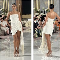 Jika kamu mengadakan pesta pernikahan outdoor, maka gaun pengantin putih pendek yang satu ini sangat cocok dan bisa dijadikan inspirasi. Gaun karya desainer Oscar de la Renta yang satu ini akan membuat penampilan terlihat simpel, santai, dan juga seksi. Aksen rumbai pada salah satu sisi gaun menambah keindahan gaun tersebut. Foto: Wolipop/Vina Oktiani