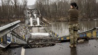 Seorang tentara wanita Ukraina mengamati jembatan Siverskiy-Donets yang hancur usai diserang Rusia, Senin (27/2/2023).