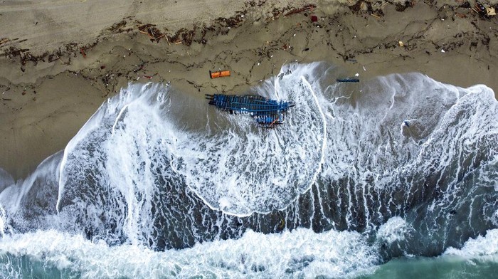 A view of part of the wreckage of a capsized boat that was washed ashore at a beach near Cutro, southern Italy, Monday, Feb. 27, 2023. Rescue crews searched by sea and air Monday for the dozens of people believed still missing from a shipwreck off Italy’s southern coast that drove home once again the desperate and dangerous crossings of migrants seeking to reach Europe. (AP Photo/Luigi Navarra)