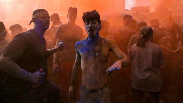 Ratusan orang ambil bagian dalam tradisi tersebut, mereka saling menyerang dengan tepung berwarna.