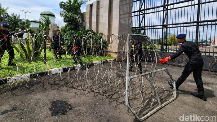 Pagar Kawat Berduri Dipasang Jelang Demo Perppu Ciptaker di DPR Petugas polisi memasang kawat berduri di depan gedung DPR, Jakarta, Selasa (28/2/2023). Pemasangan tersebut mengantisipasi rencana aksi massa di depan DPR terkait sejumlah isu seperti penolakan Perppu Cipta Kerja.