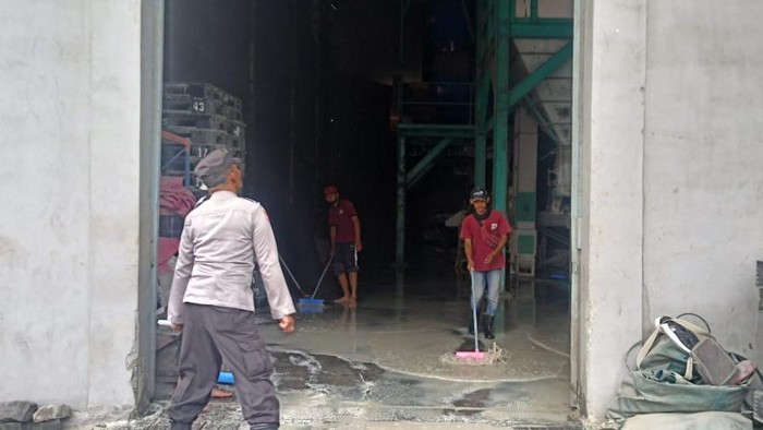 Petugas membersihkan sisa-sisa kebakaran di gudang beras di Kediri
