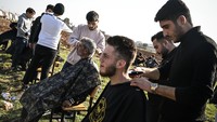 Para relawan ini menyediakan layanan potong rambut gratis untuk para korban gempa di pengungsian.  
