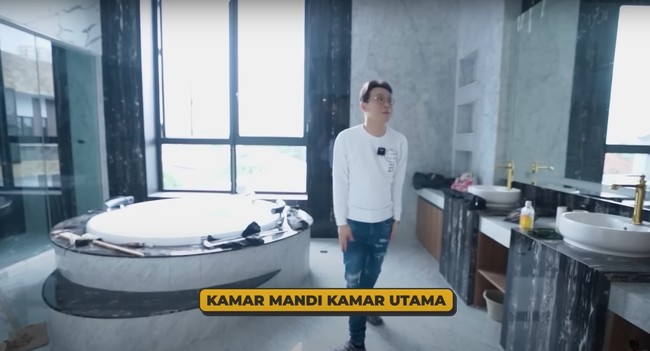 Kamar mandi utama di rumah tersebut juga tak kalah mewah dan luas. Dilengkapi dengan jacuzzi bathtub, TV, dan cermin besar di dekat 2 wastafelnya. Foto: YouTube/dr. Richard Lee, MARS